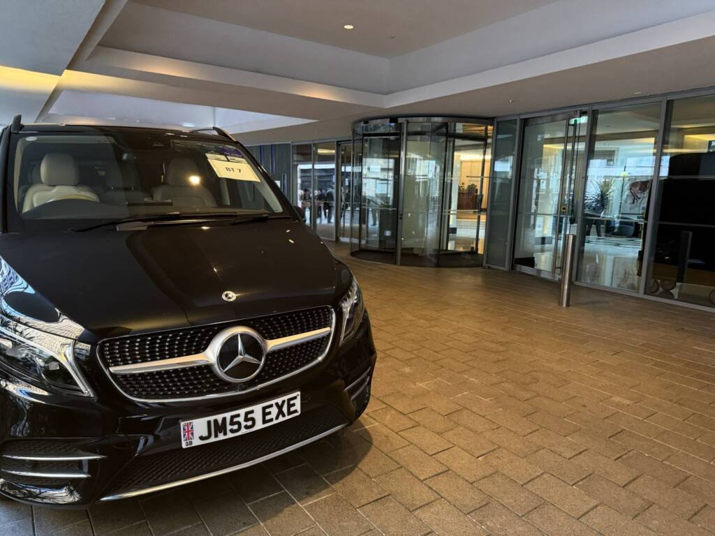 Black Mercedes V-Class at a hotel entrance