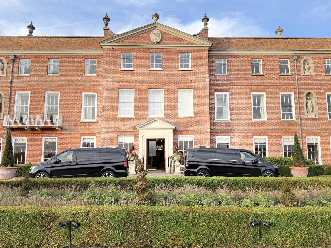 Chauffeur vehicles outside a luxury country house hotel.
